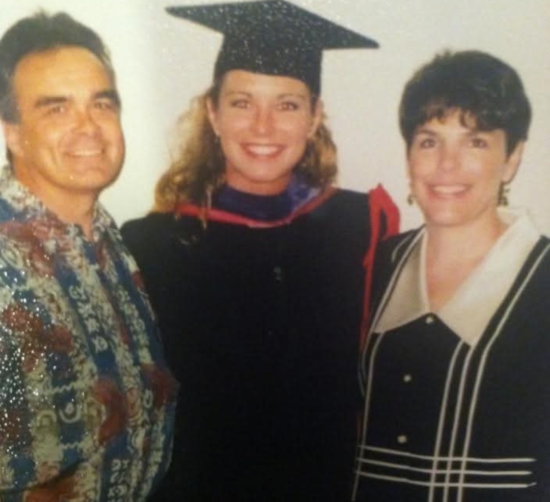 Sarah N. Dimmich in cap and gown at her 2002 law school commencement, between her parents